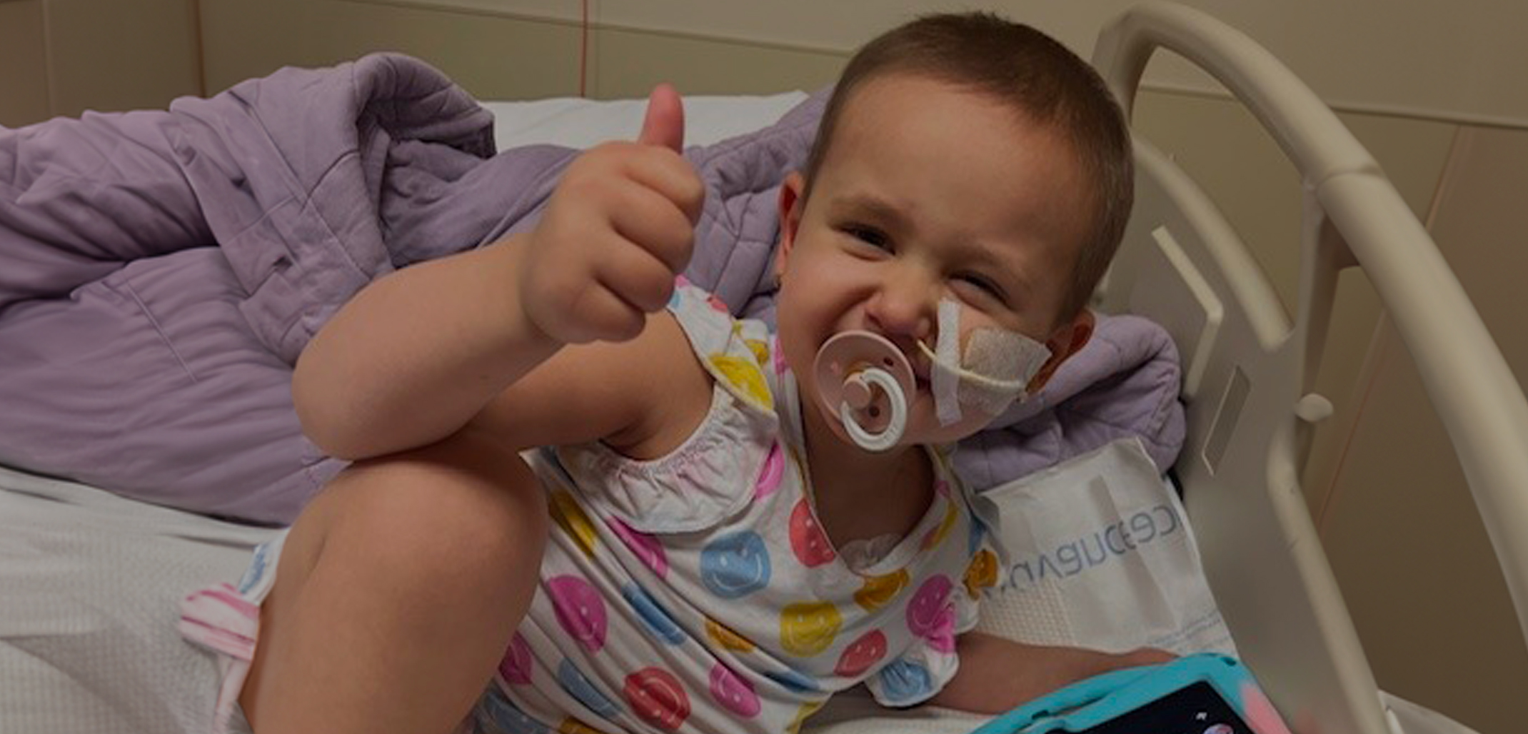 Picture of a cancer fighter in the hospital giving a thumbs up