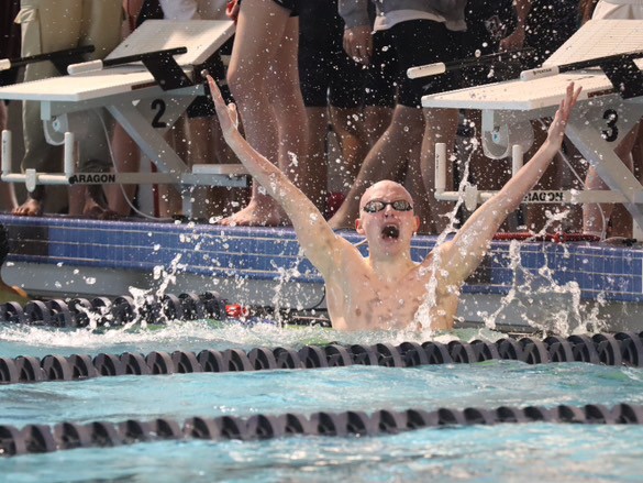 Jack Punswick after completing his swim race with arms up