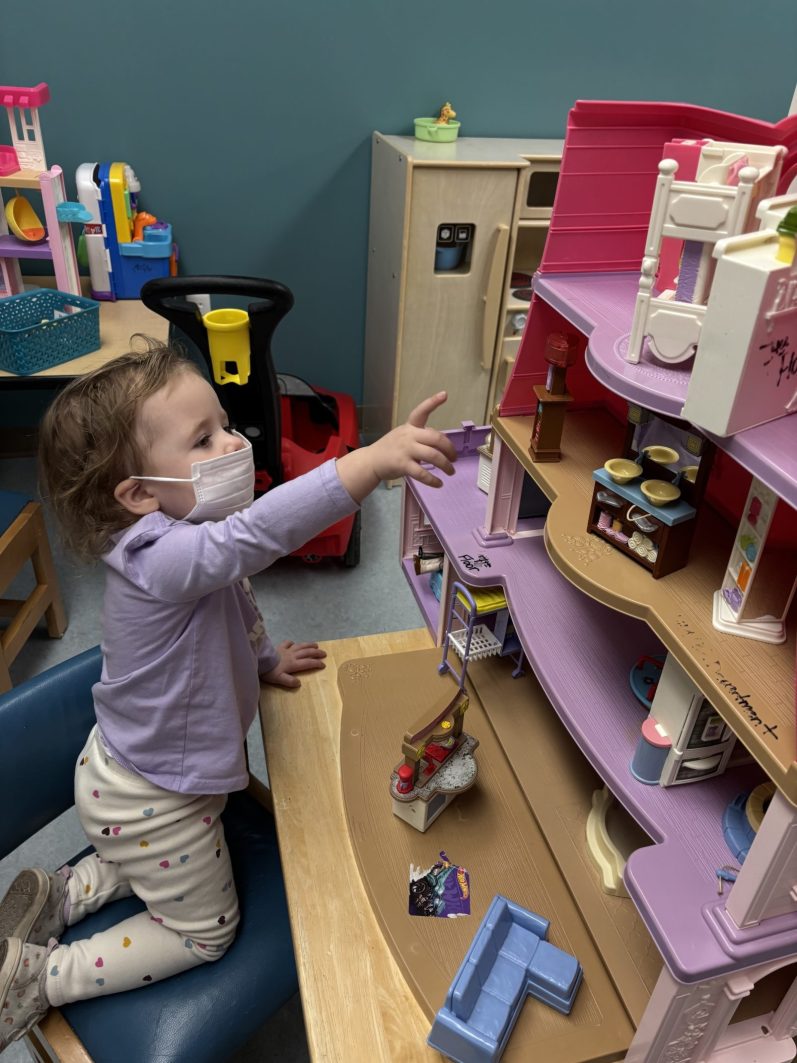 Emma playing with a doll house
