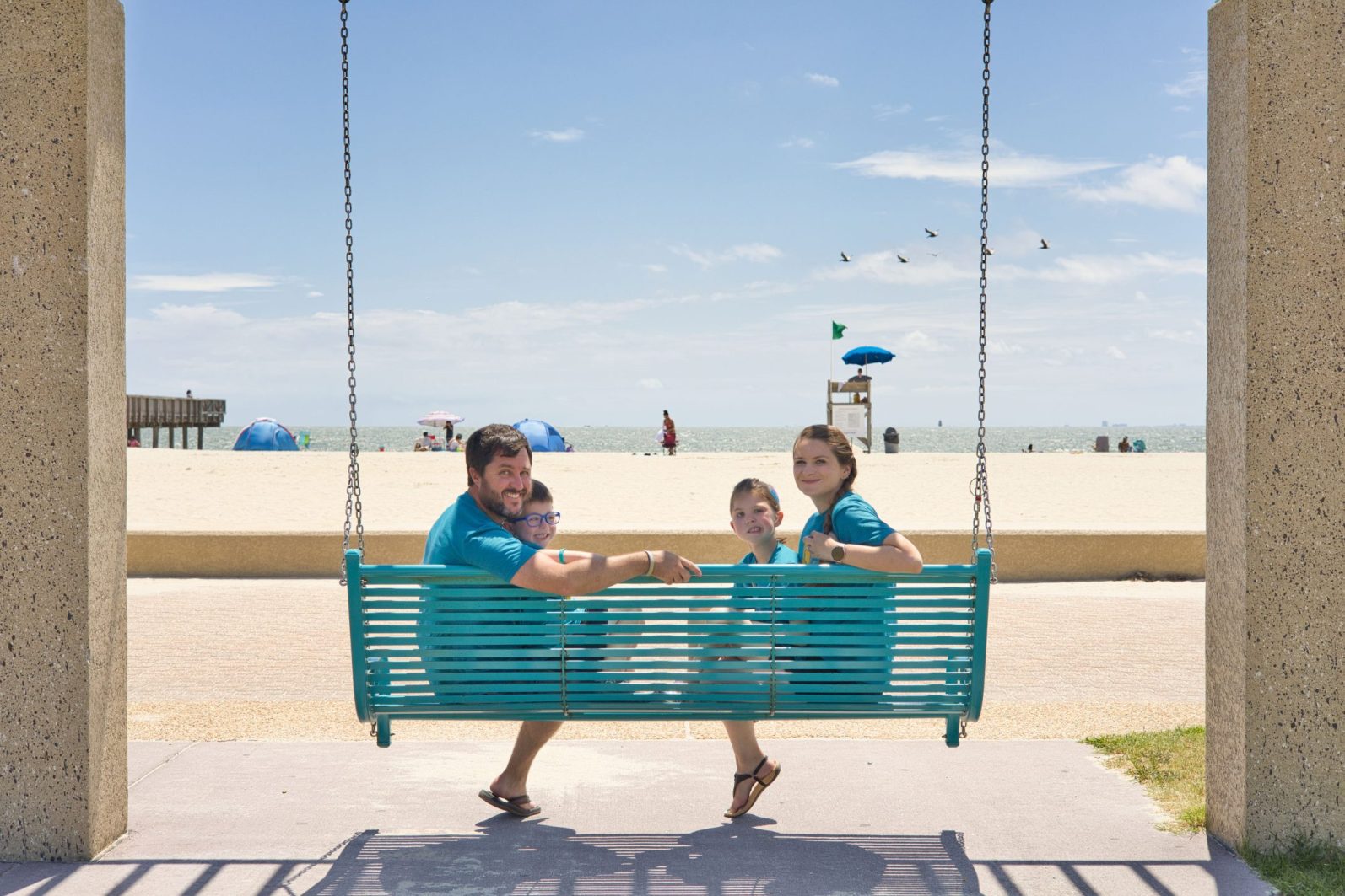 Eva with her family on a swing at the beach