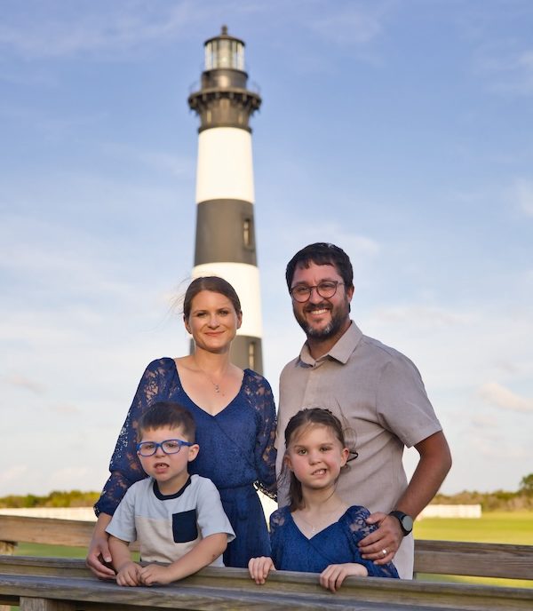 Eva with her family in front of a lighthouse