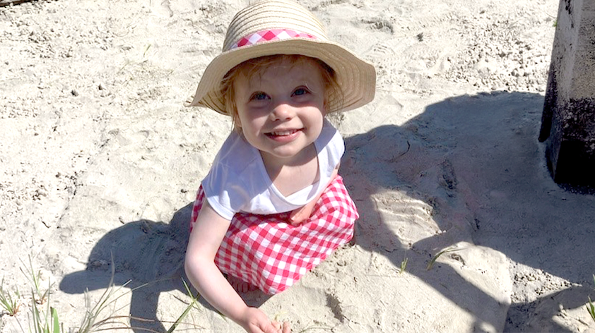 Ella playing with sand on the beach